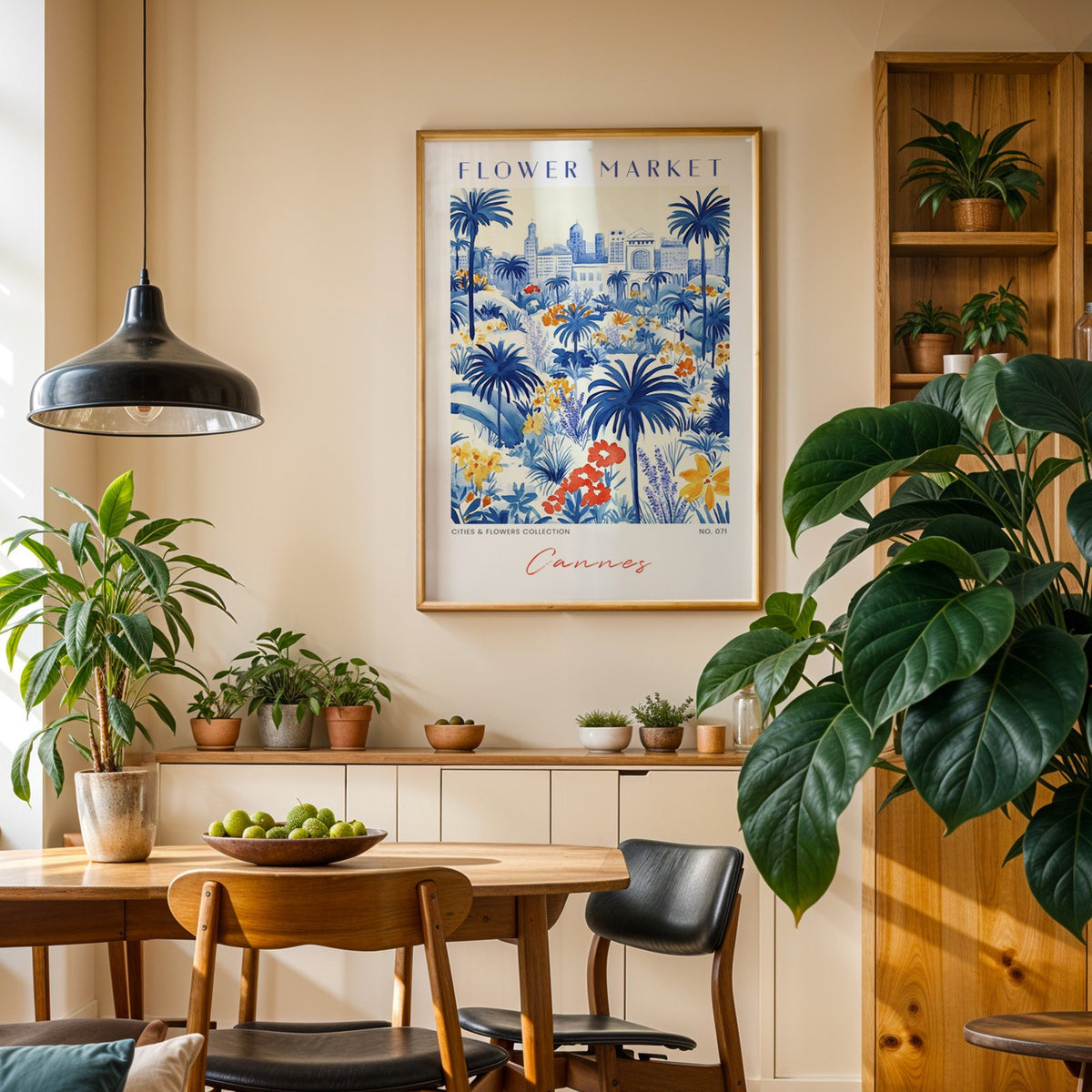 Cannes flower market print in an oak frame above a dining sideboard lined with potted plants