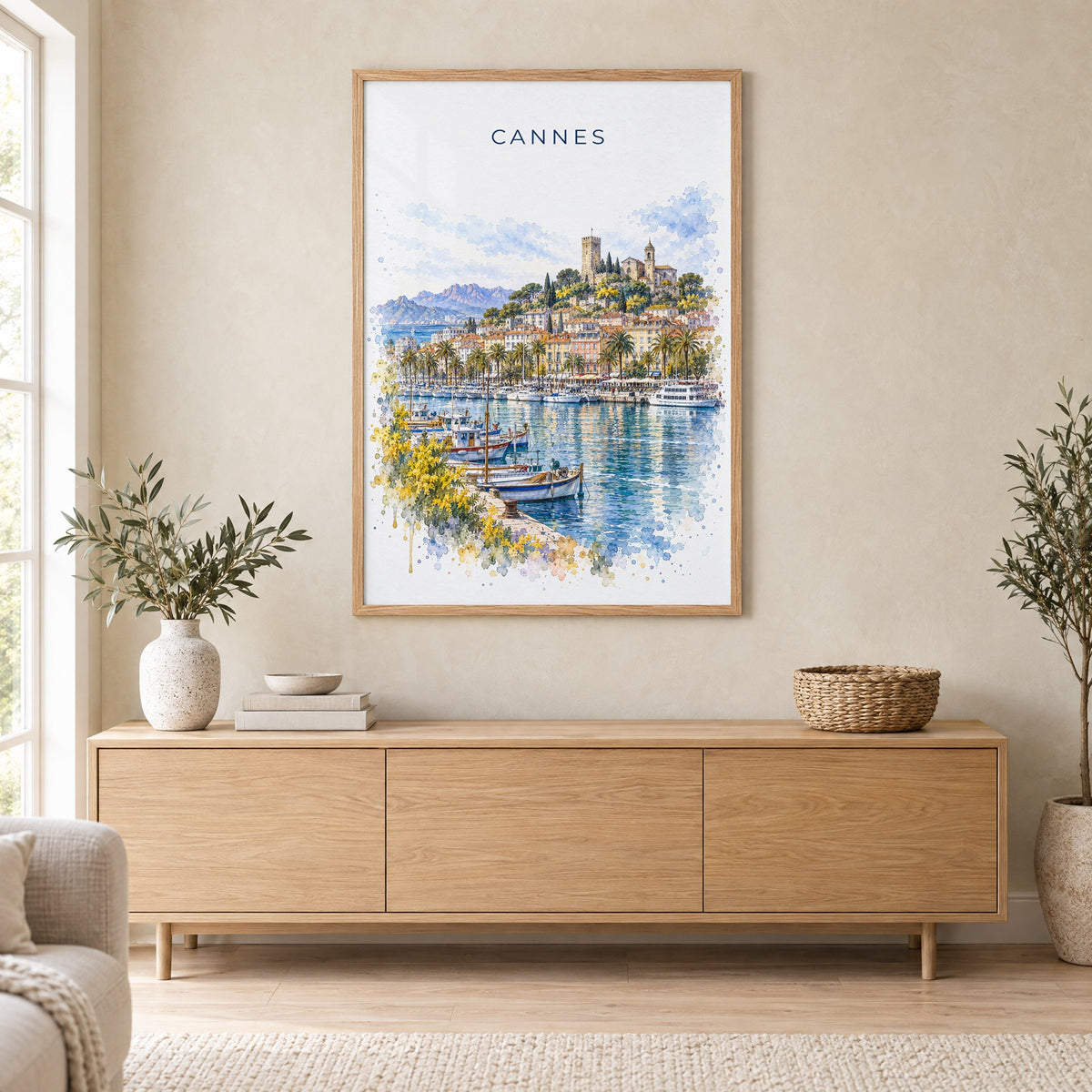 Cannes watercolor print in an oak frame above a light wood sideboard in a Scandinavian living room
