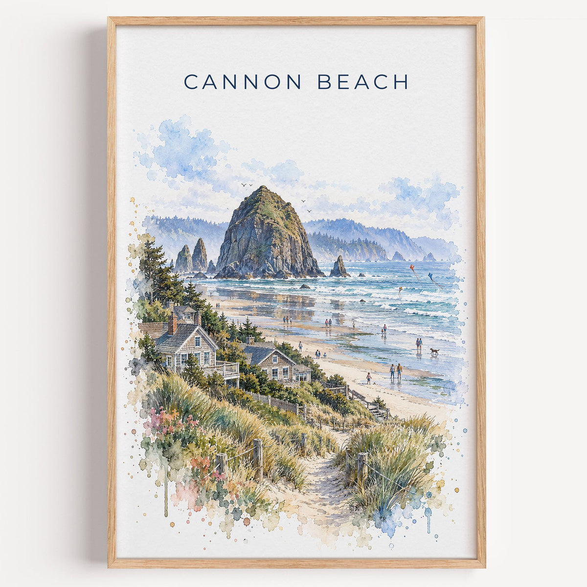 Cannon Beach watercolor print in a light oak frame on a plain white wall