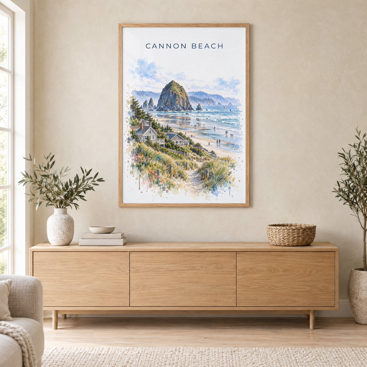 Cannon Beach watercolor print in an oak frame above a light wood sideboard in a Scandinavian living room