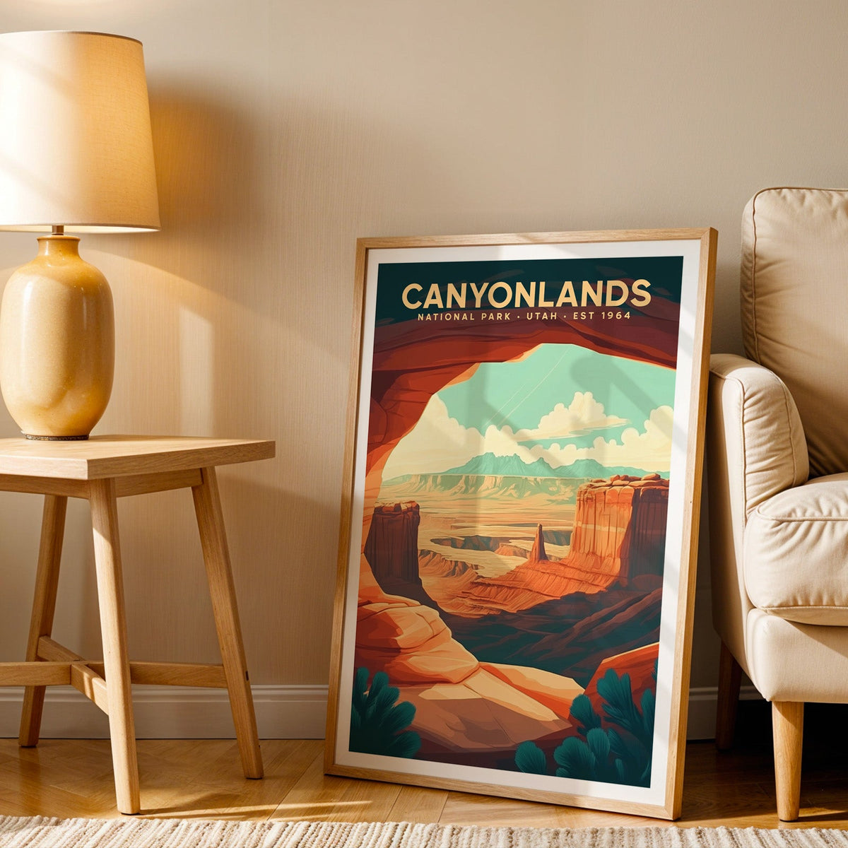 Canyonlands print in an oak frame beside a cream armchair and an amber lamp in warm light