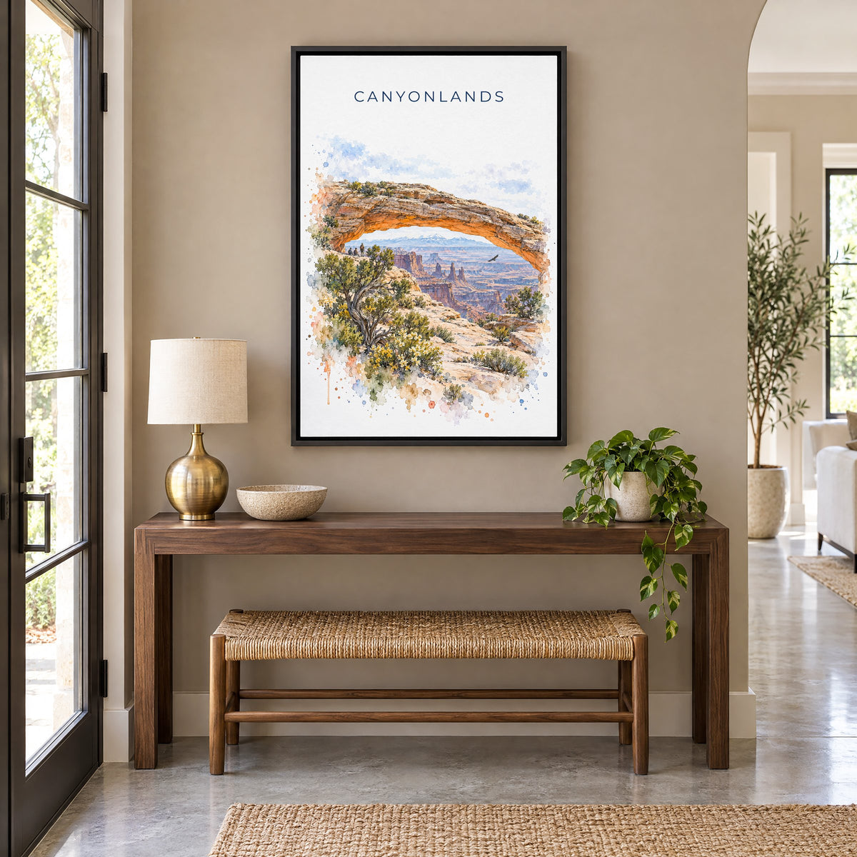 Canyonlands National Park watercolor print as a black floater canvas above a walnut console and woven bench in an entryway