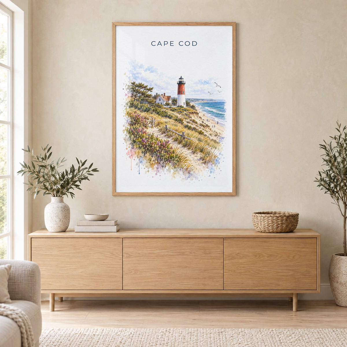 Cape Cod National Seashore watercolor print in an oak frame above a light wood sideboard in a Scandinavian living room