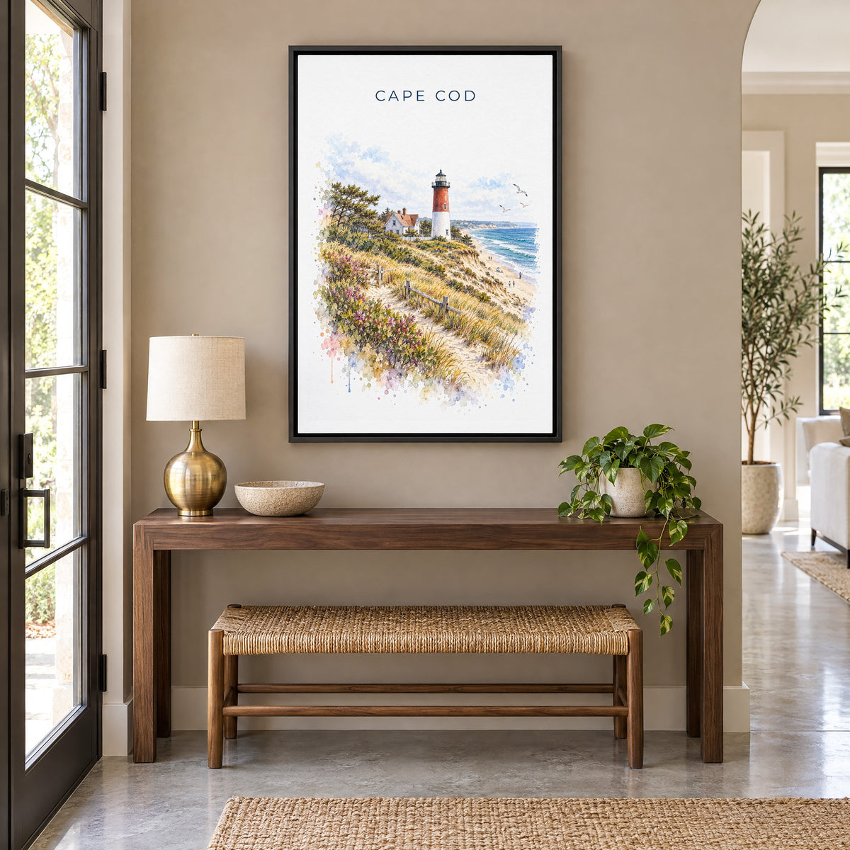 Cape Cod National Seashore watercolor print as a black floater canvas above a walnut console and woven bench in an entryway