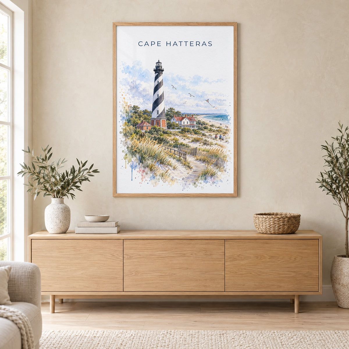 Cape Hatteras watercolor print in an oak frame above a light wood sideboard in a Scandinavian living room