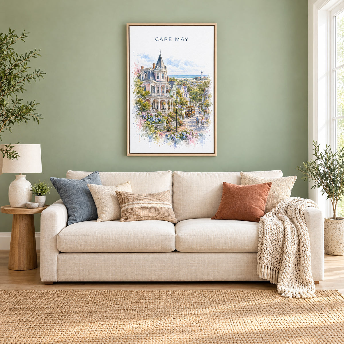 Cape May watercolor print as a natural floater canvas above a cream linen sofa on a sage green wall