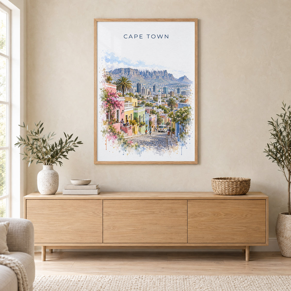 Cape Town watercolor print in an oak frame above a light wood sideboard in a Scandinavian living room