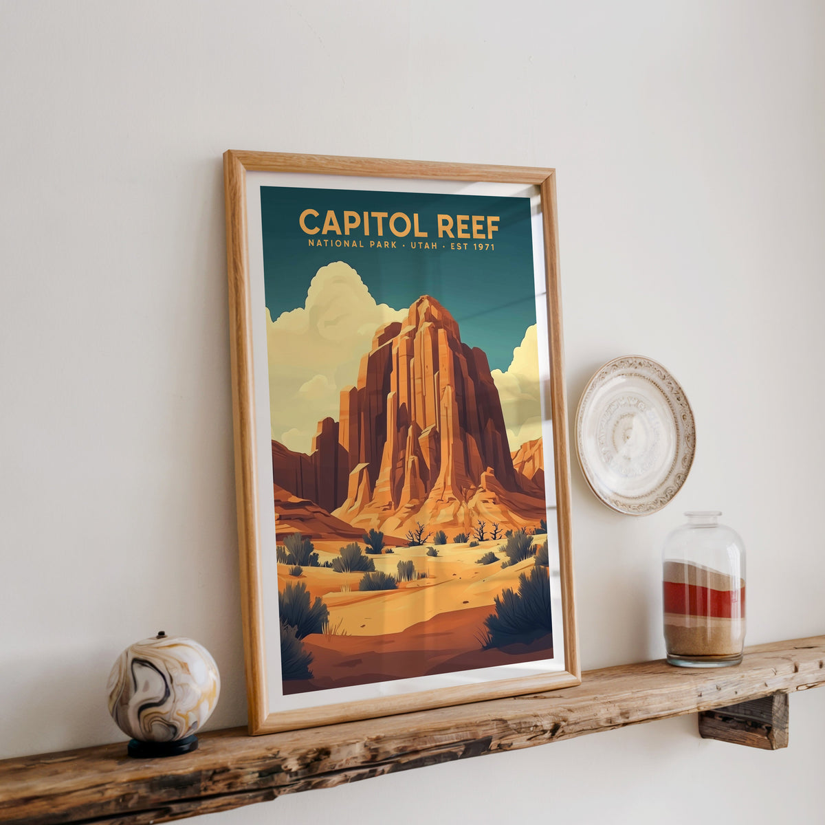 Capitol Reef National Park print in an oak frame on a rustic wood shelf with ceramics and a jar