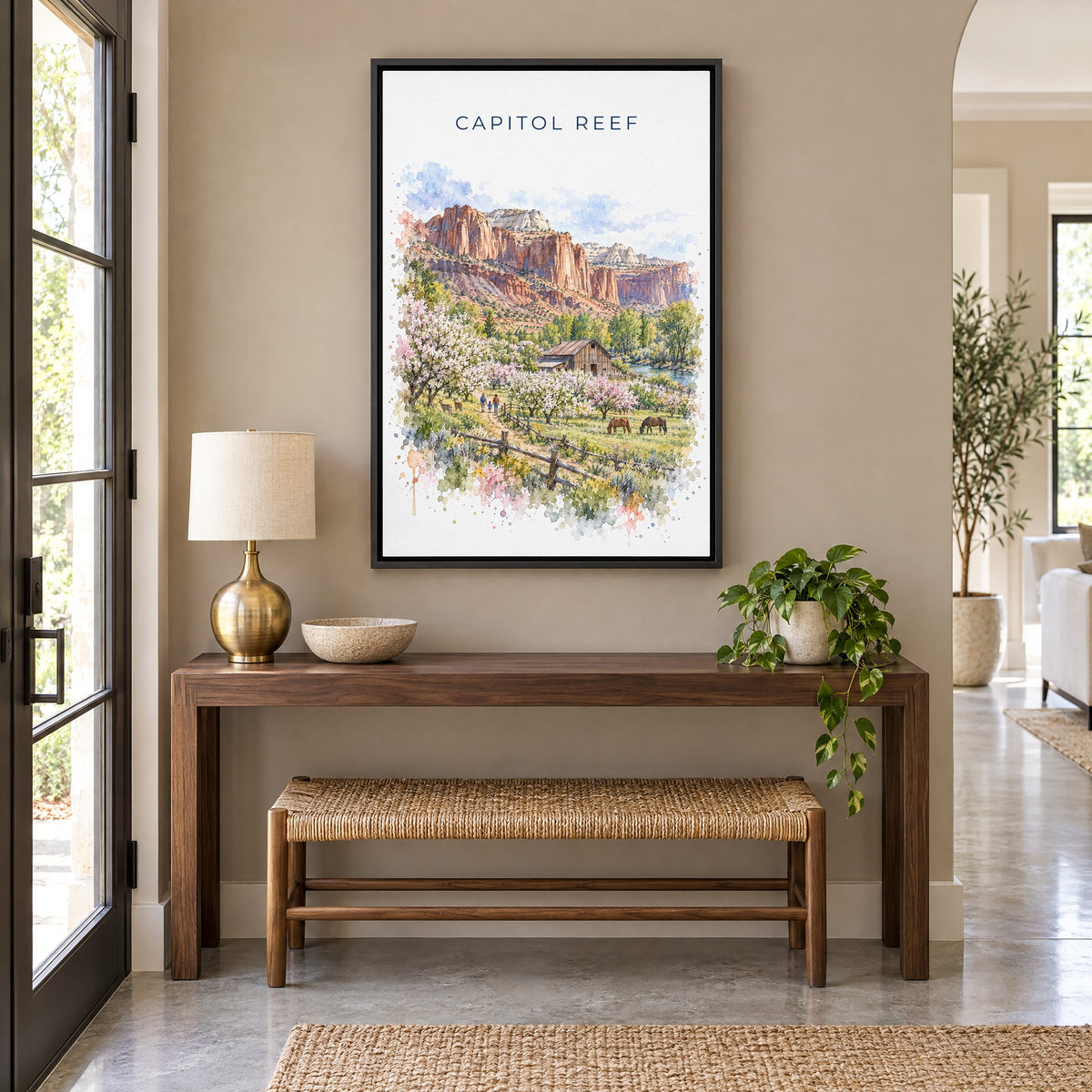 Capitol Reef National Park watercolor print as a black floater canvas above a walnut console and woven bench in an entryway