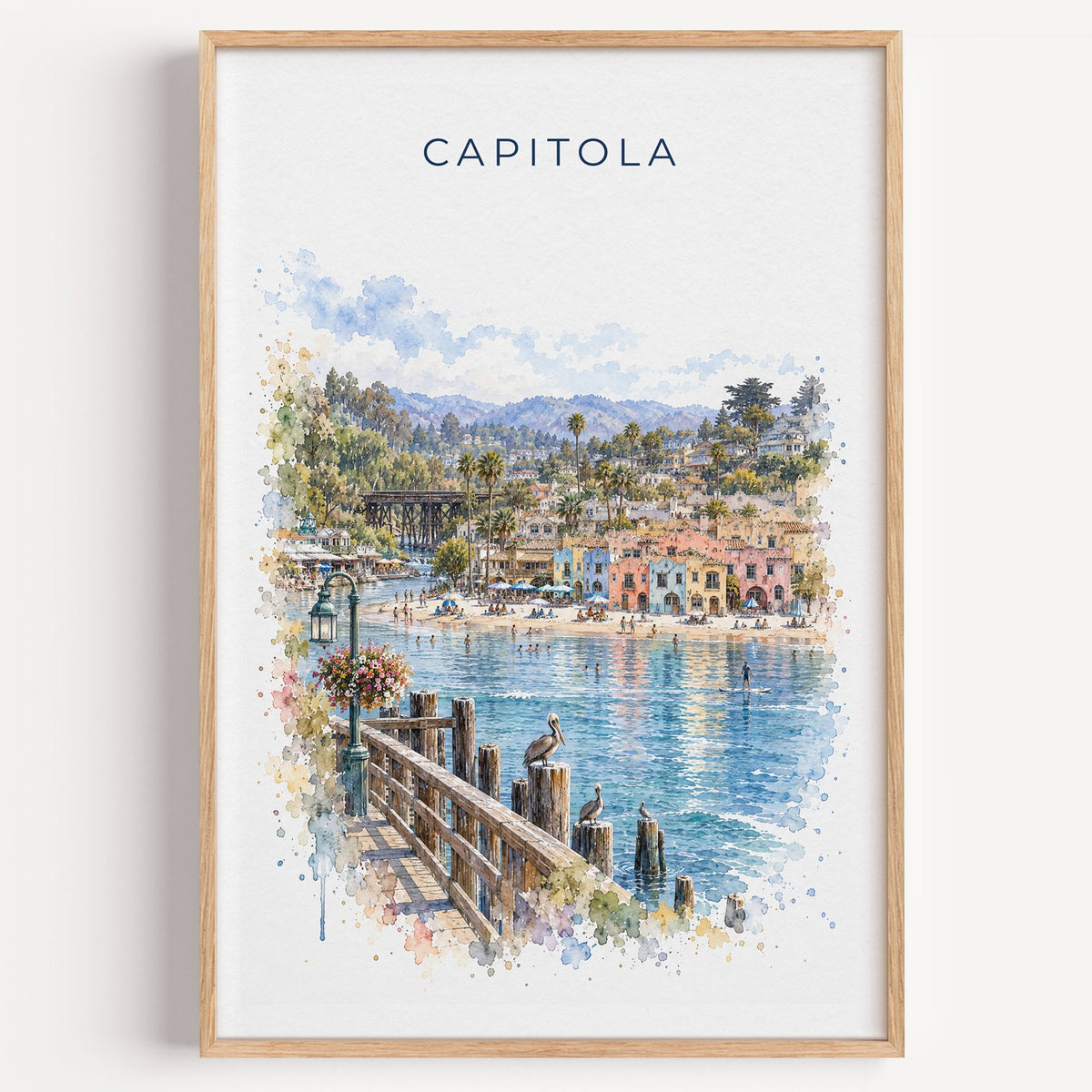 Capitola, California watercolor print in a light oak frame on a plain white wall