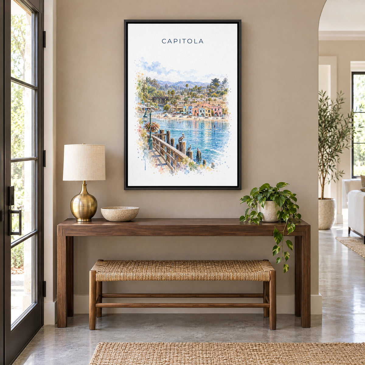 Capitola, California watercolor print as a black floater canvas above a walnut console and woven bench in an entryway