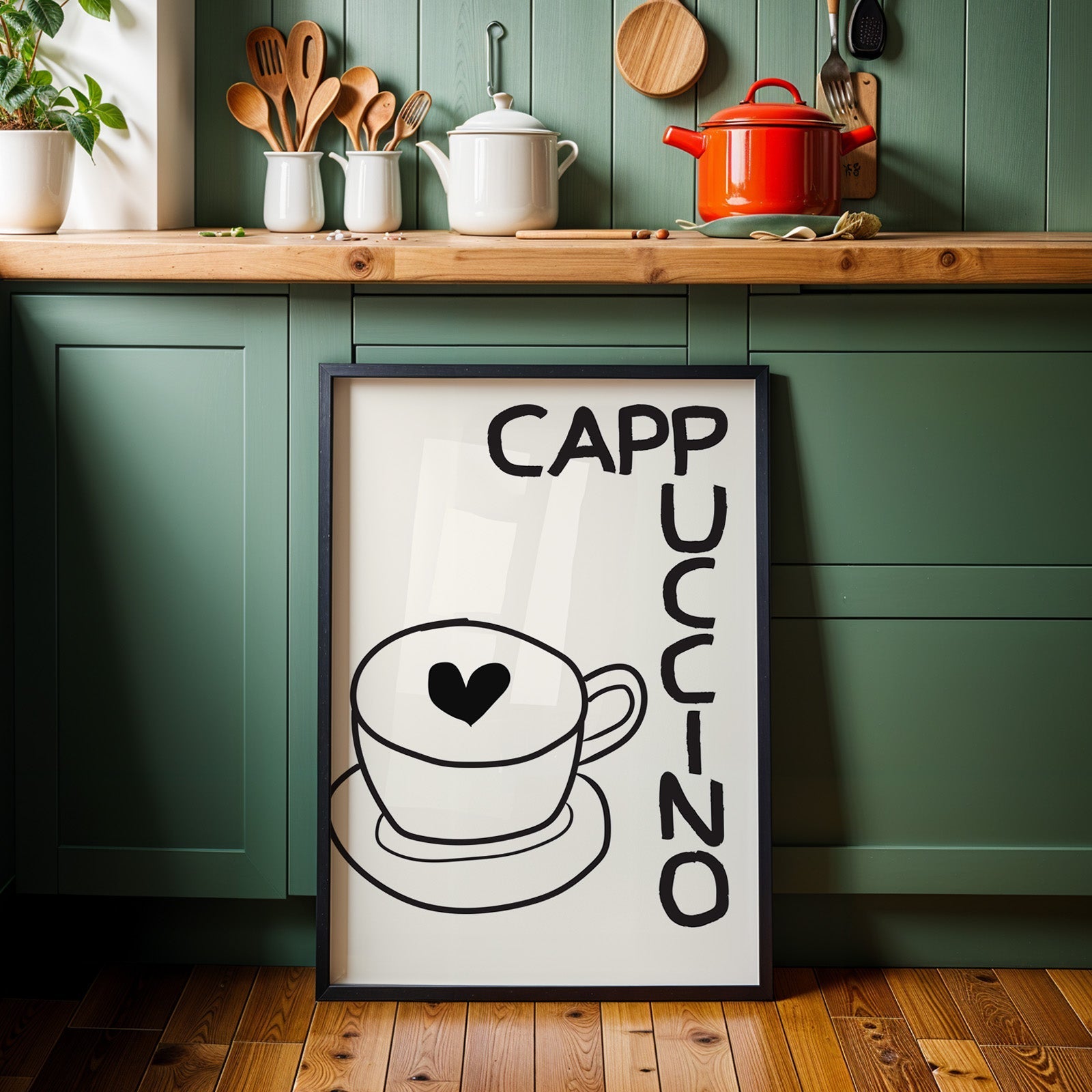 Cappuccino heart print in a black frame against sage green kitchen cabinets