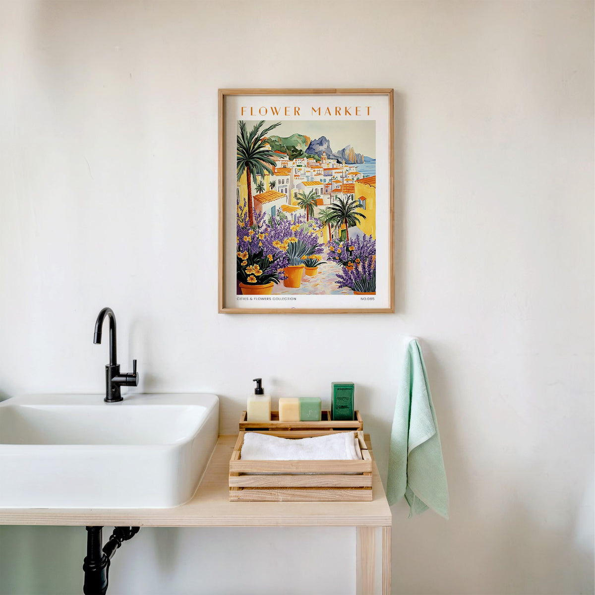 Capri flower market print in an oak frame above a white bathroom sink with folded towels