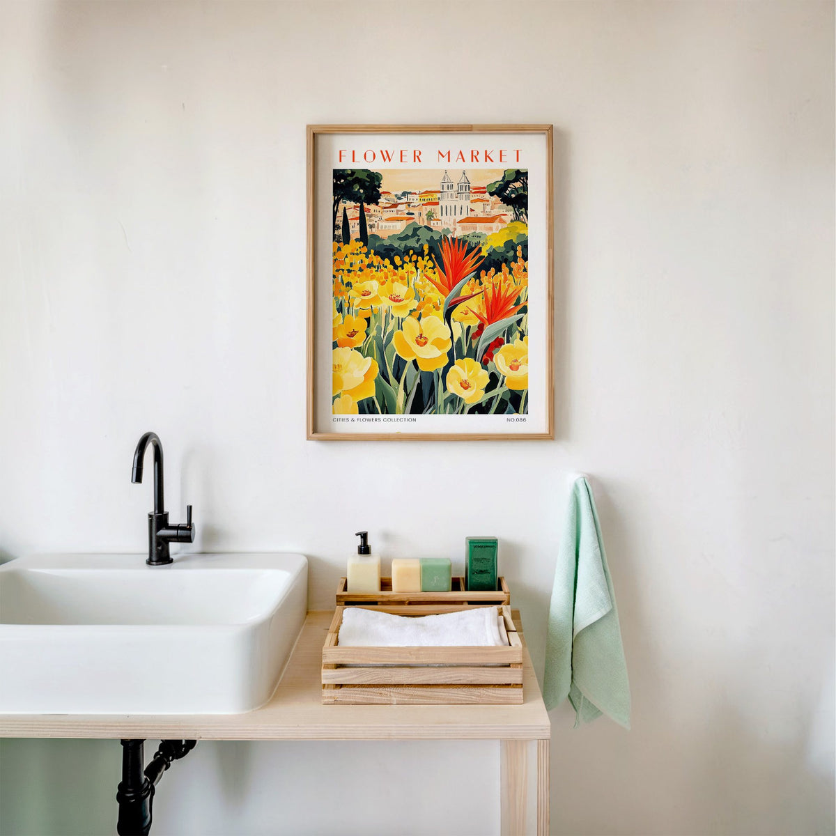 Caracas flower market print in an oak frame above a white bathroom sink with folded towels
