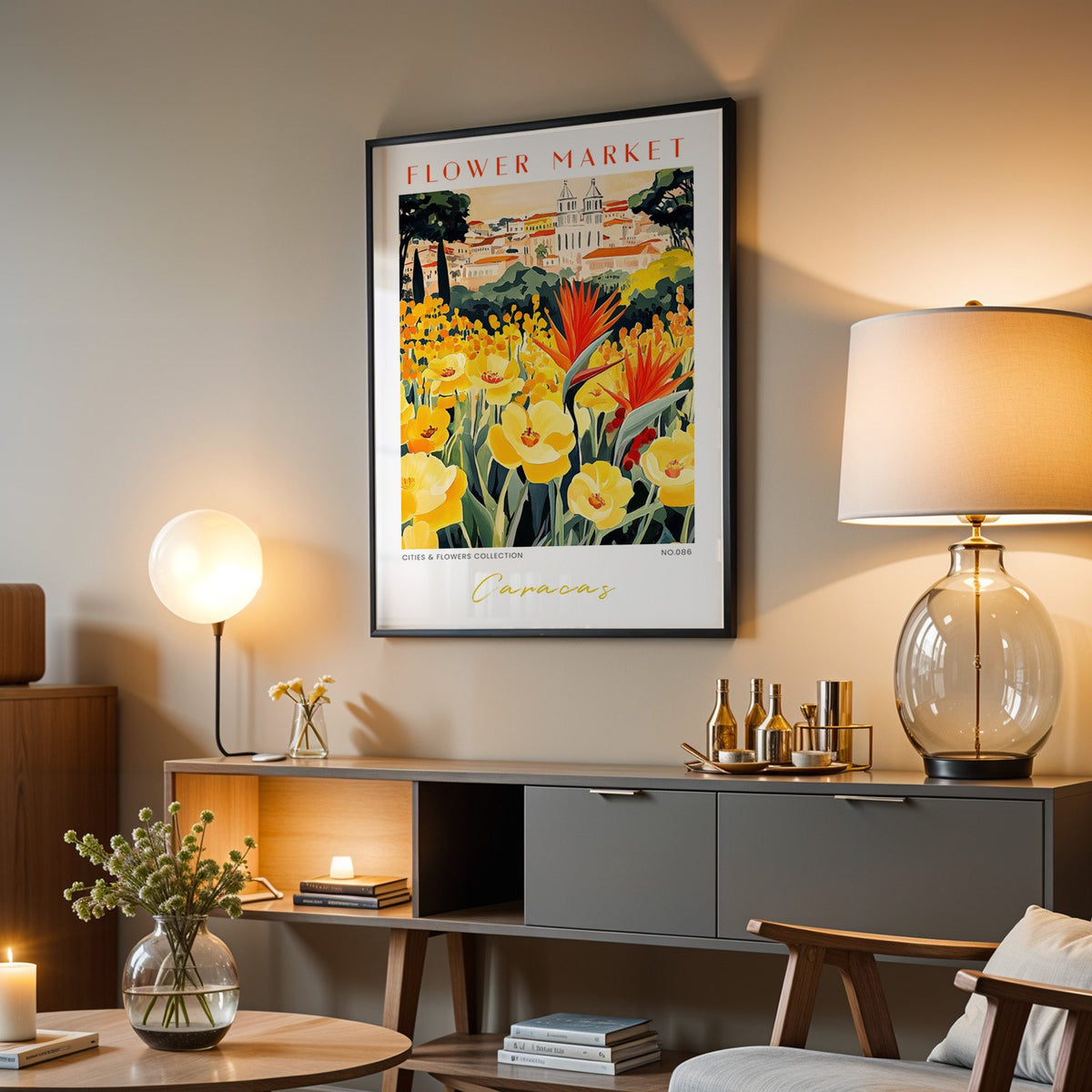 Caracas flower market print in a black frame above a grey media console with a glass table lamp