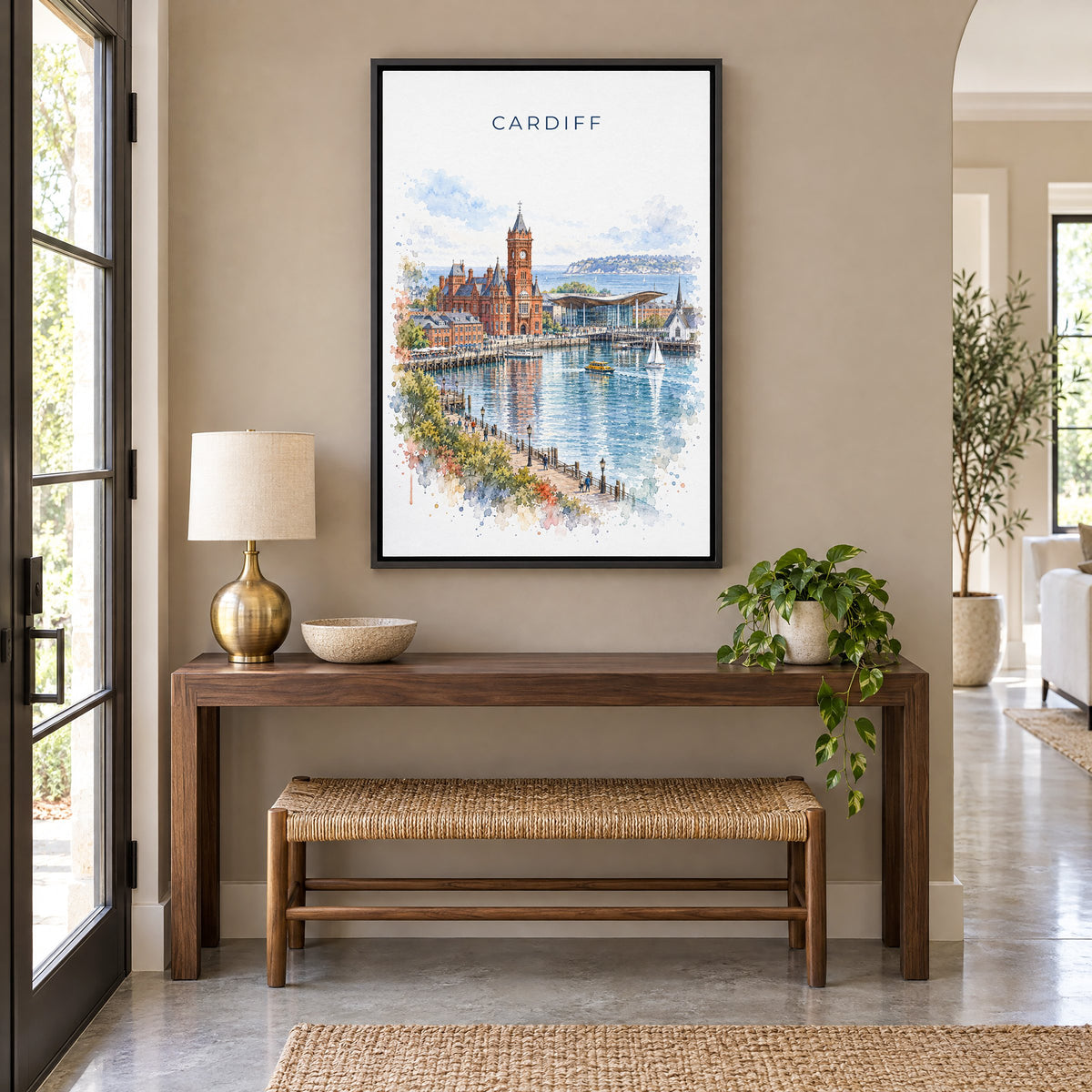 Cardiff watercolor print as a black floater canvas above a walnut console and woven bench in an entryway