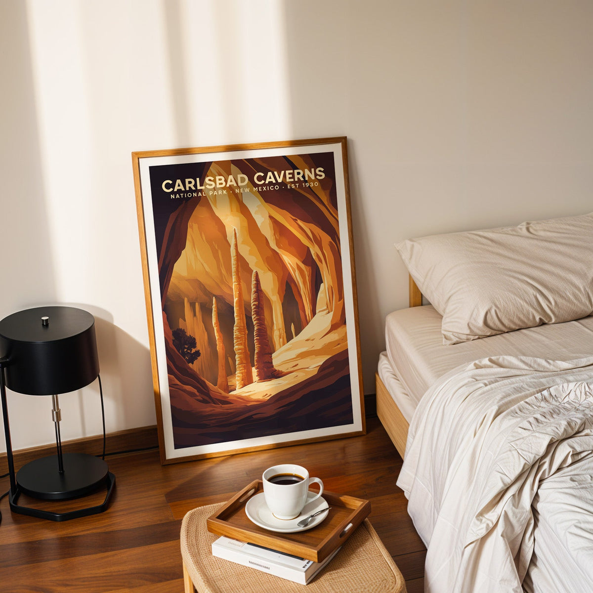 Carlsbad Caverns print in an oak frame leaning on a bedroom floor beside the bed and a tray