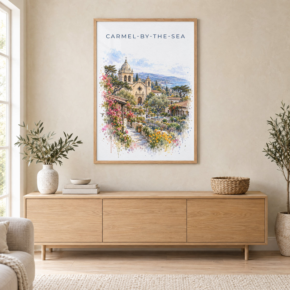 Carmel-by-the-Sea watercolor print in an oak frame above a light wood sideboard in a Scandinavian living room