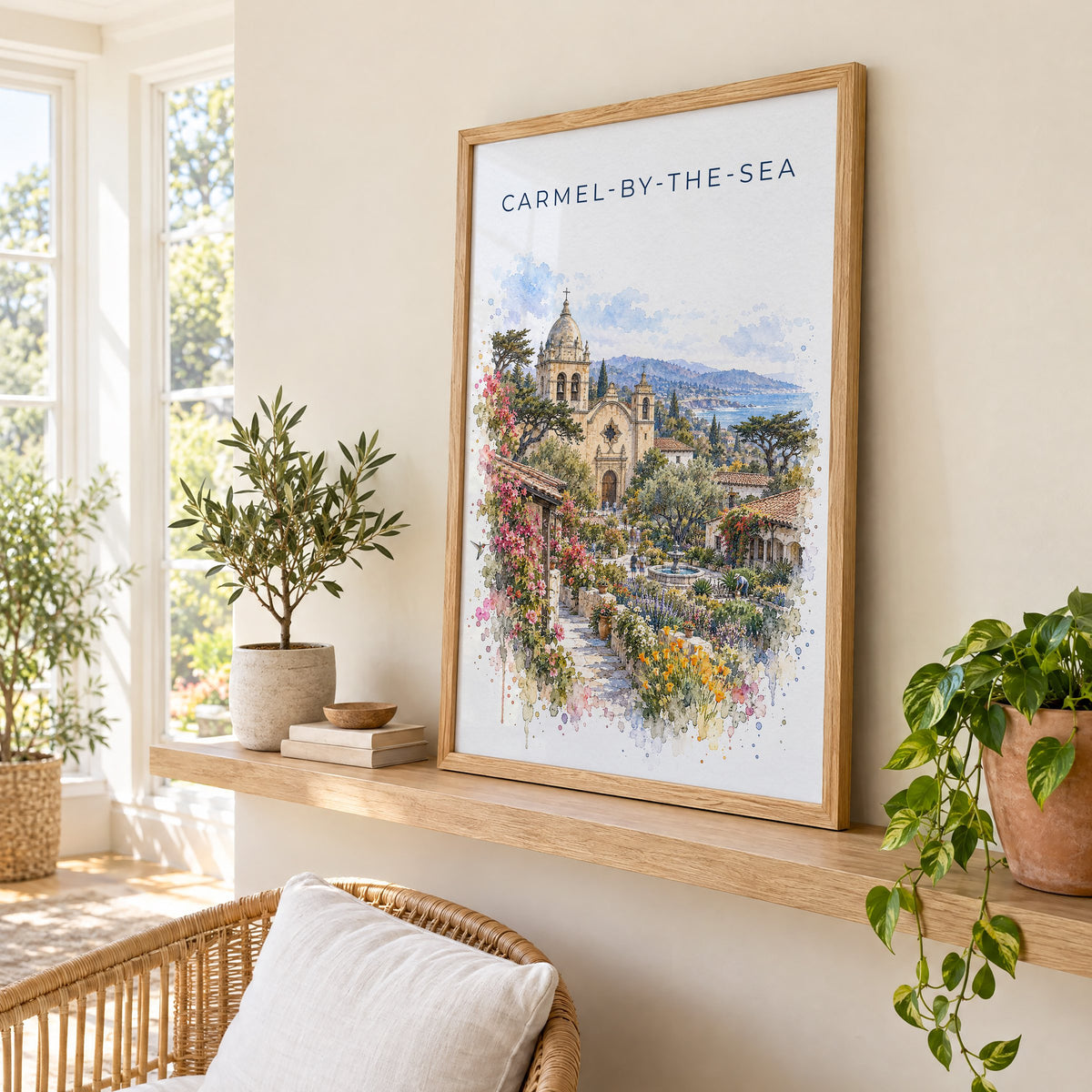 Carmel-by-the-Sea watercolor print in an oak frame on a picture ledge in a sunlit sunroom