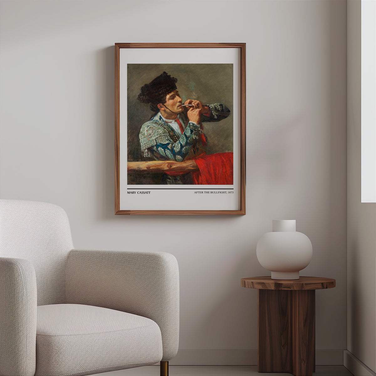 Matador portrait print in a slim walnut frame above a bouclé armchair