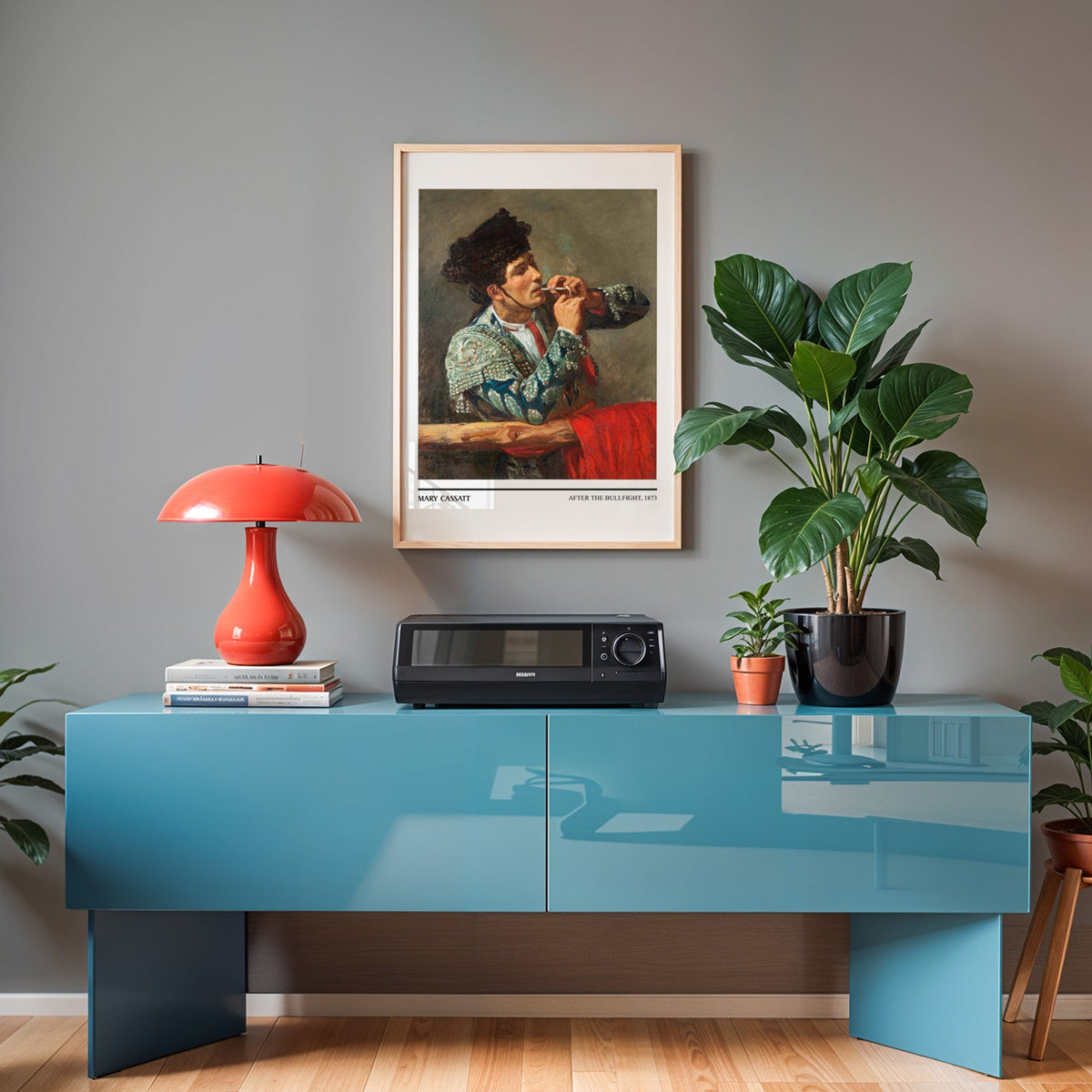 Cassatt Spanish portrait print in an oak frame above a teal sideboard with a red lamp