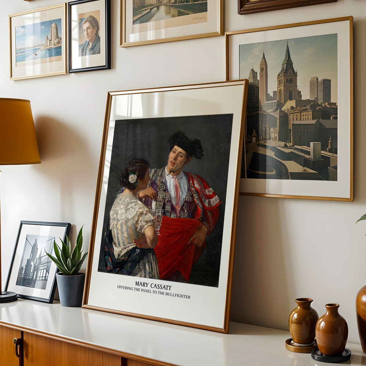 Matador painting print shown in a gold frame leaning on a sideboard in a gallery wall