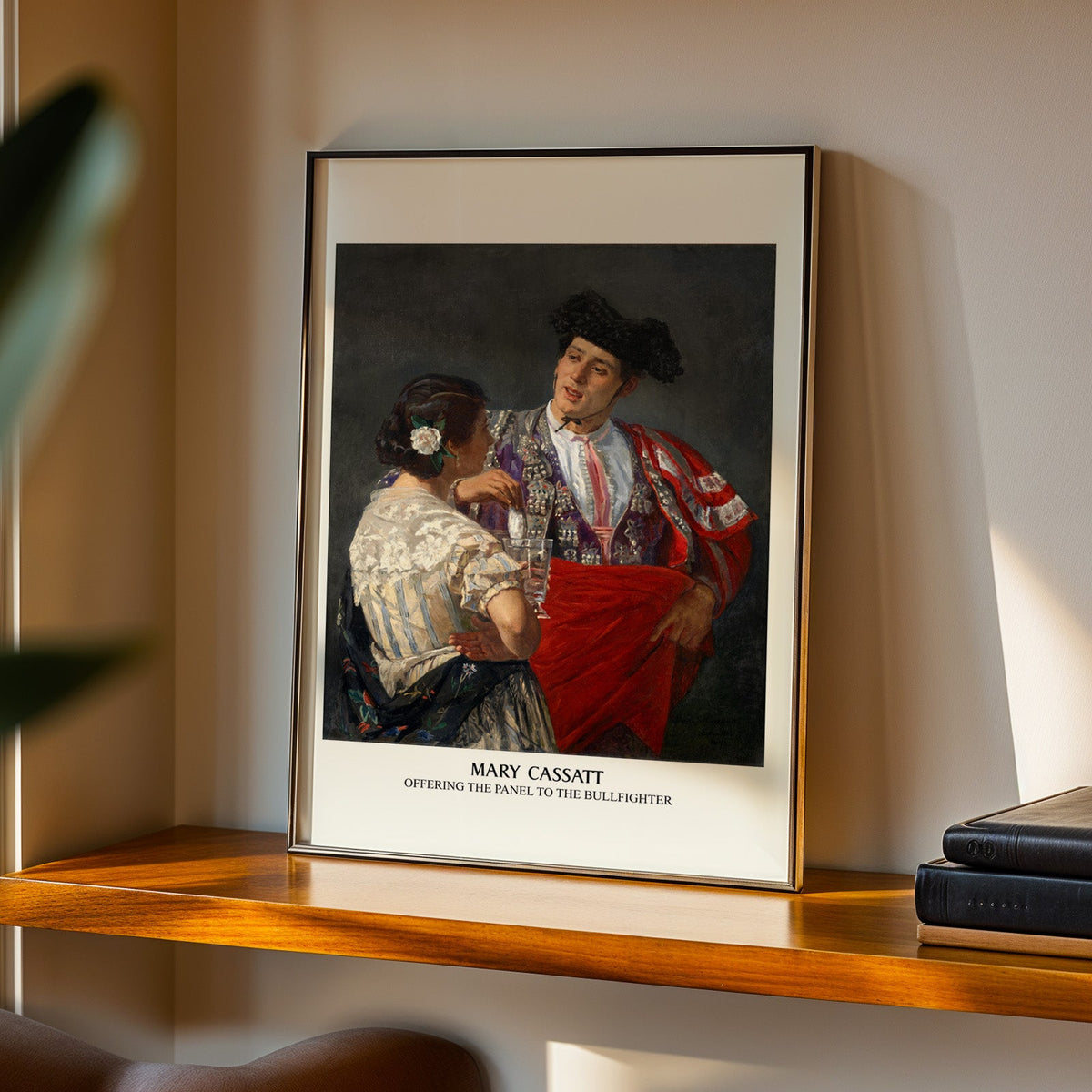 Mary Cassatt Spanish print in a black frame on a walnut shelf in evening light
