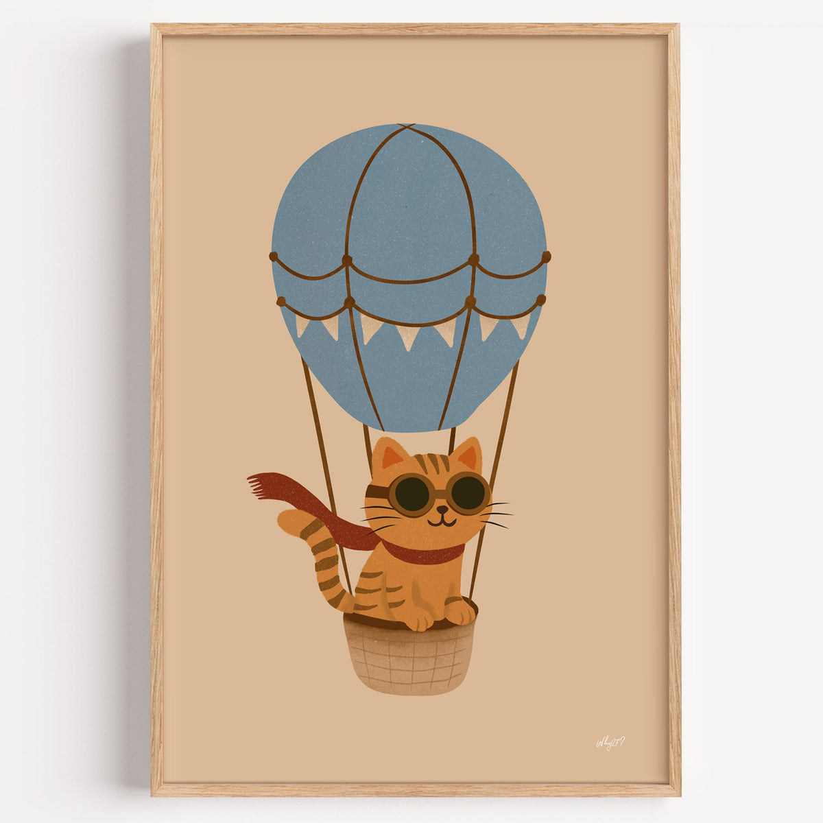 Cat in blue hot air balloon nursery print in a light oak frame on a plain white wall