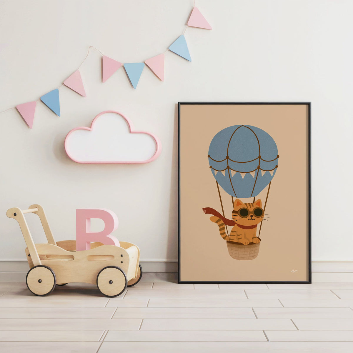 Cat in blue hot air balloon nursery print in a black frame under pastel bunting by a wooden baby walker
