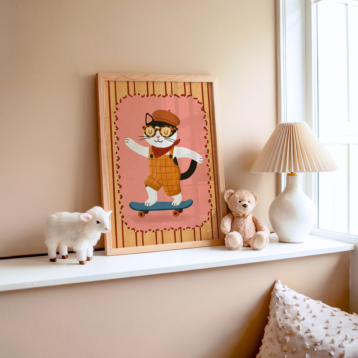 Black and white cat on skateboard nursery print in an oak frame on a window ledge with a toy lamb and teddy