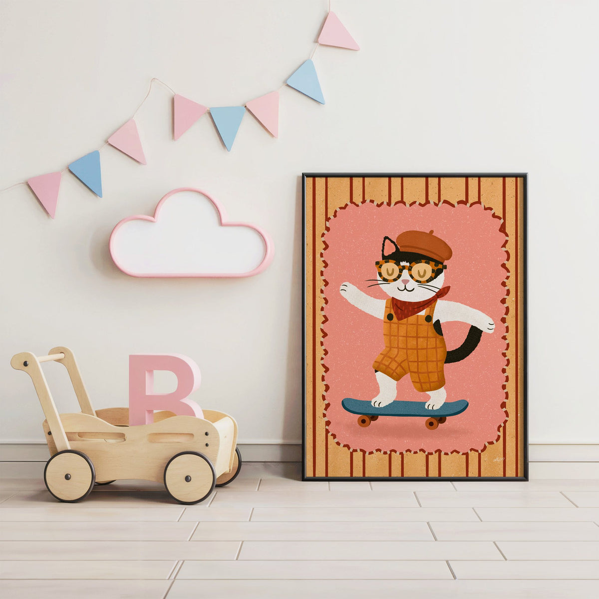 Black and white cat on skateboard nursery print in a black frame under pastel bunting by a wooden baby walker