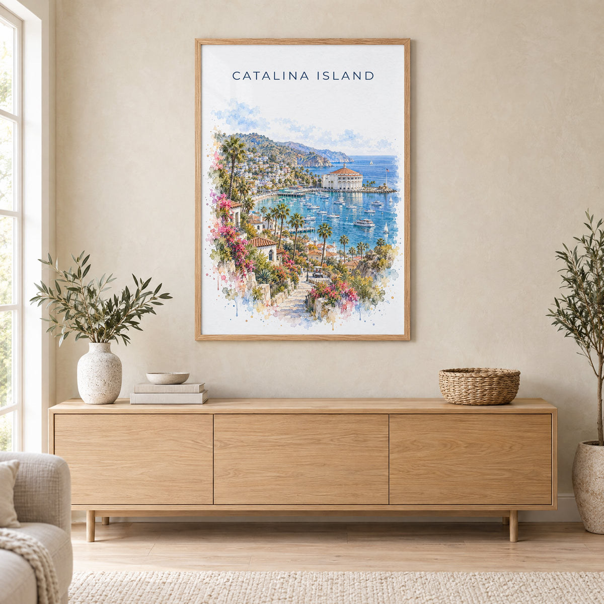 Catalina Island watercolor print in an oak frame above a light wood sideboard in a Scandinavian living room