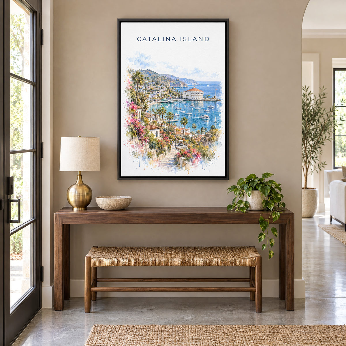 Catalina Island watercolor print as a black floater canvas above a walnut console and woven bench in an entryway