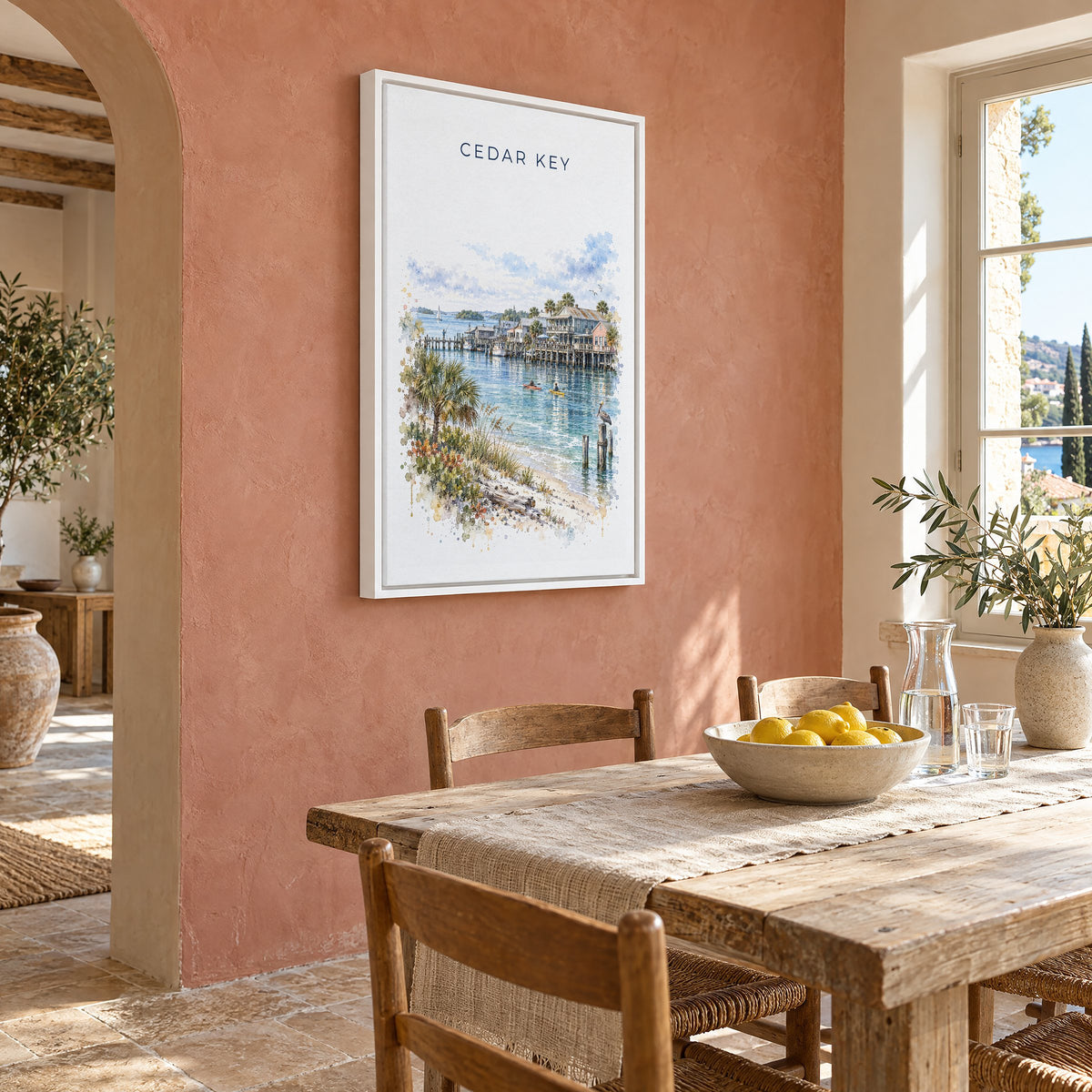 Cedar Key, Florida watercolor print as a white floater canvas on a terracotta wall above a rustic dining table