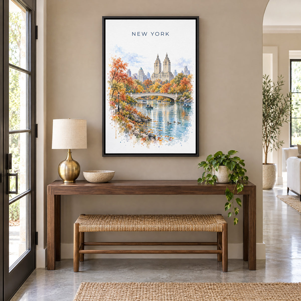 Central Park watercolor print as a black floater canvas above a walnut console and woven bench in an entryway