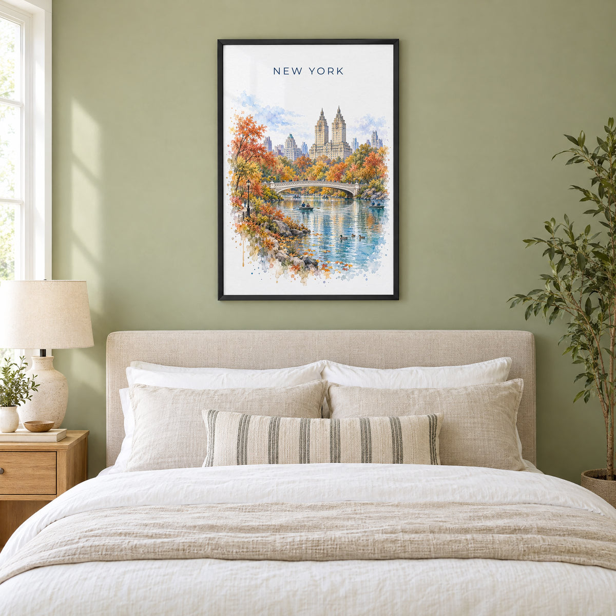 Central Park watercolor print in a black frame above an upholstered headboard in a sage green bedroom