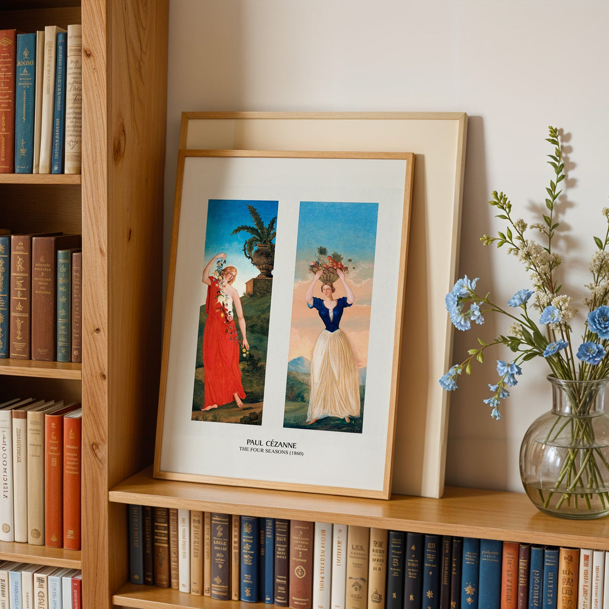 French figure painting print in an oak frame leaning on a bookshelf beside flowers