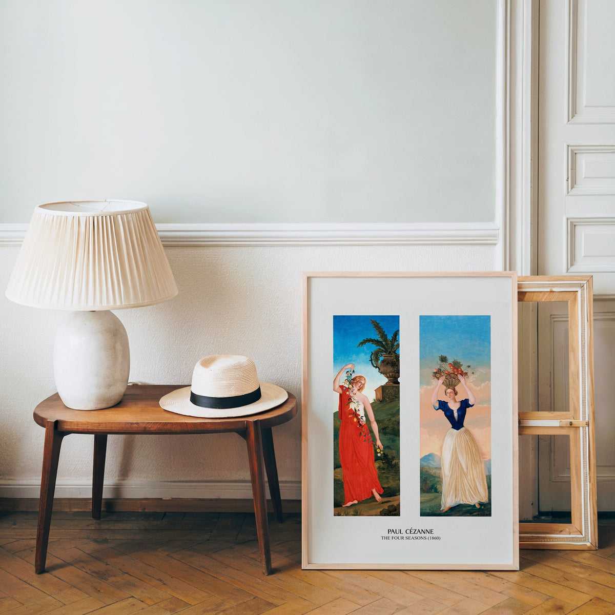 Post-impressionist poster in a light wood frame leaning by a bench and hat