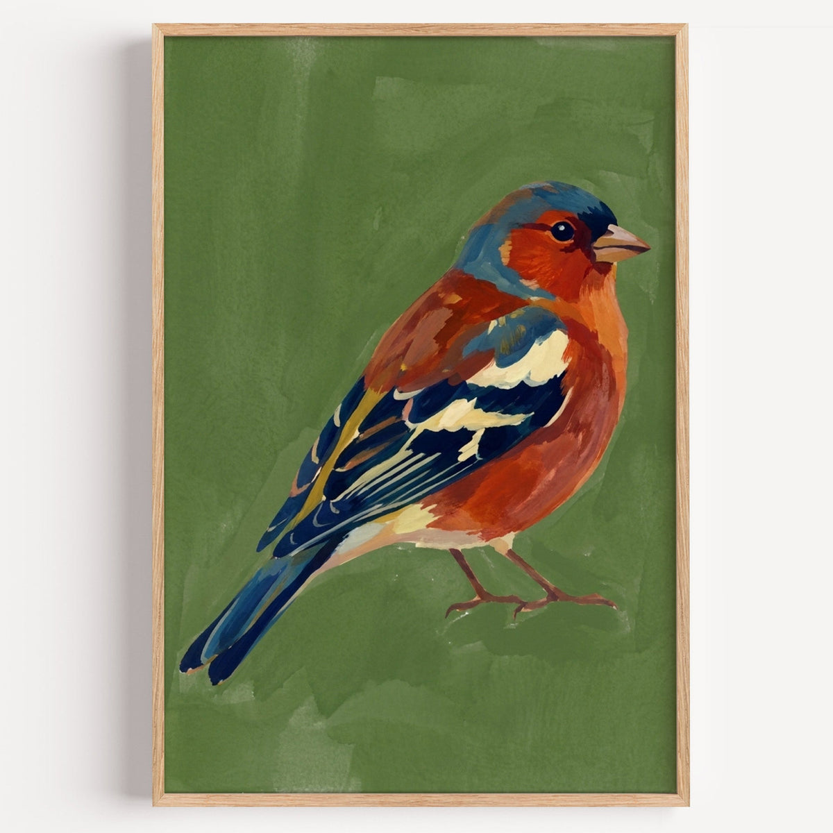 Chaffinch bird print in a light oak frame on a plain white wall