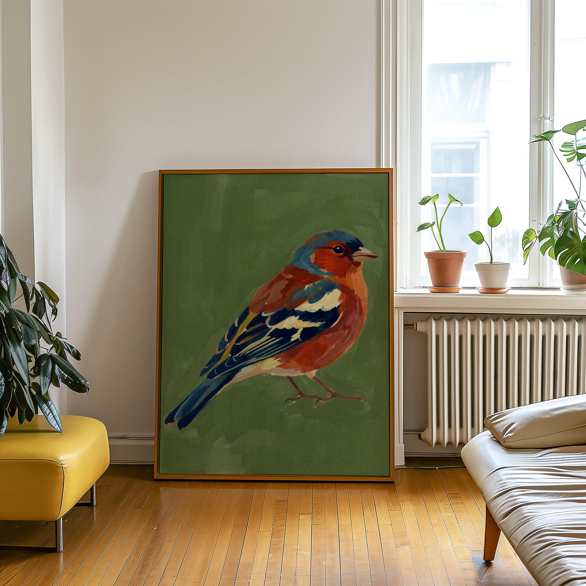 Red breasted songbird print in an oak frame leaning beside a yellow leather bench