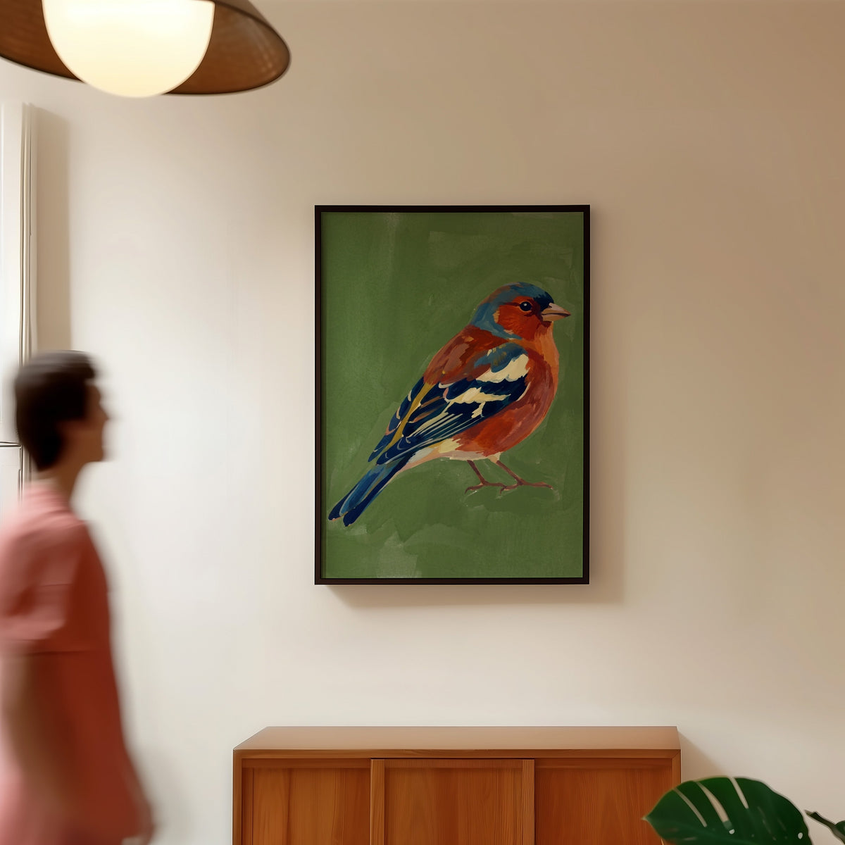 Garden bird wall art print in a black frame in a hallway under a rattan pendant