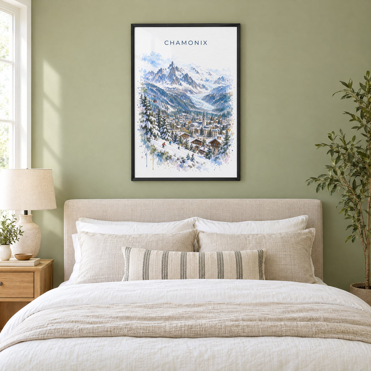 Chamonix watercolor print in a black frame above an upholstered headboard in a sage green bedroom