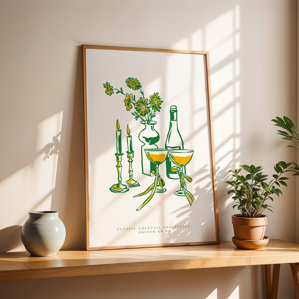 Champagne coupes and daisies print in a slim oak frame on a console with a grey-blue vase