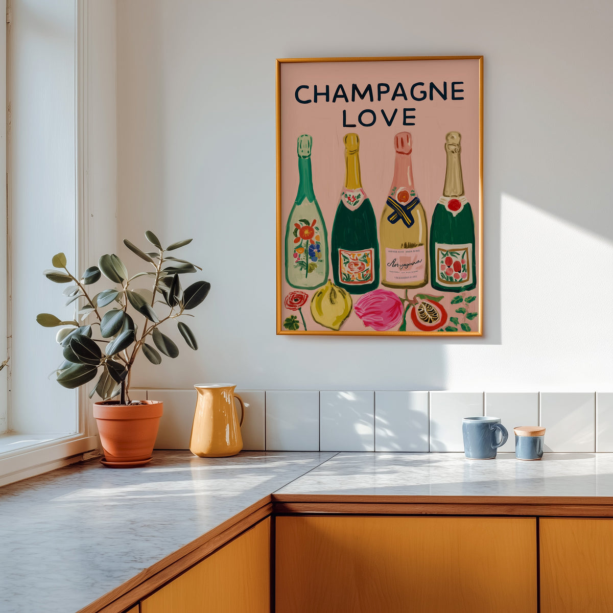 Champagne Love print shown in a gold frame above a marble counter in a tan kitchen