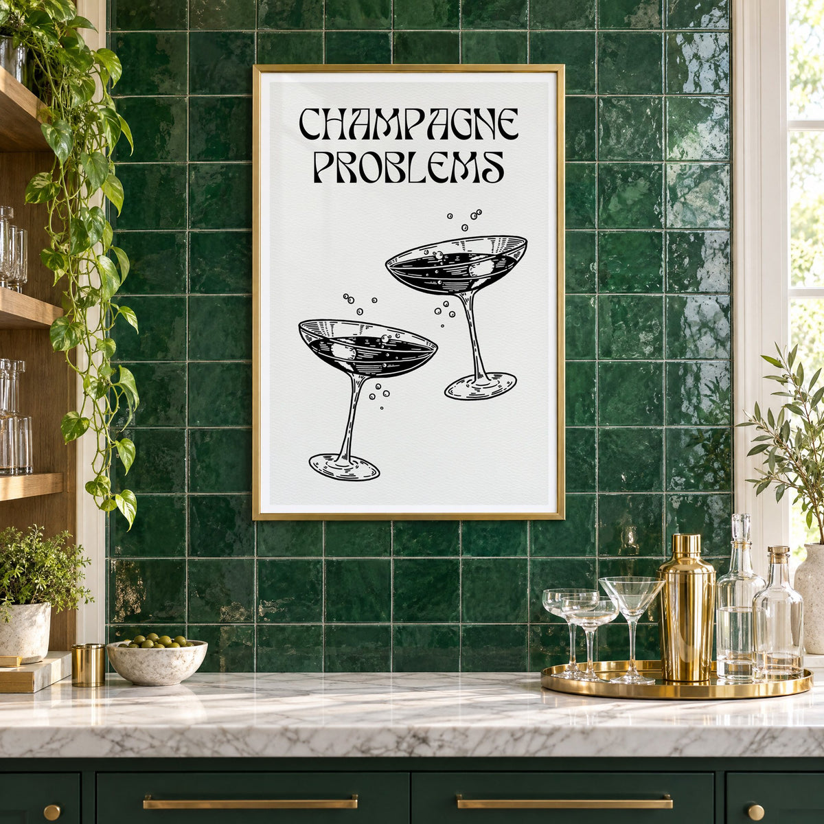 Champagne Problems engraved coupes print in a brass frame on emerald green tiles above a home bar with coupe glasses