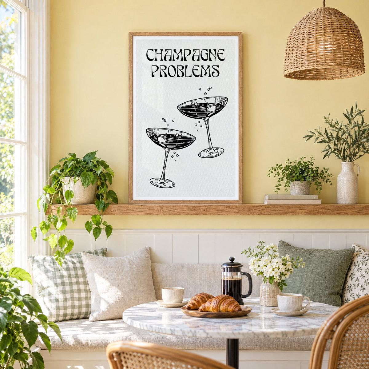Champagne Problems engraved coupes print in an oak frame on a picture ledge above a sunny breakfast nook