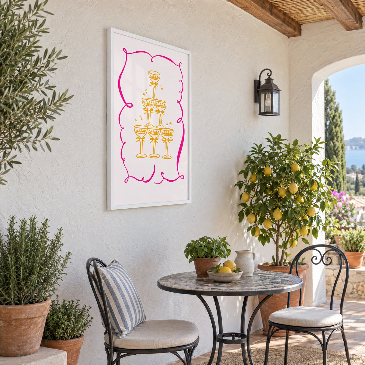 Champagne tower pink ribbon frame print in a white frame on a sunny patio wall beside a potted lemon tree