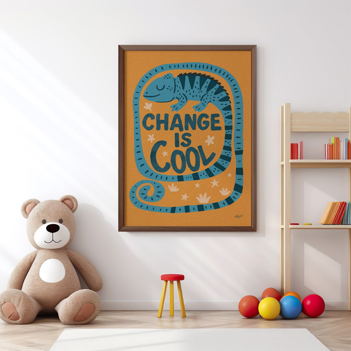 Change is cool chameleon orange nursery print in a walnut frame above a big teddy bear by a bookshelf