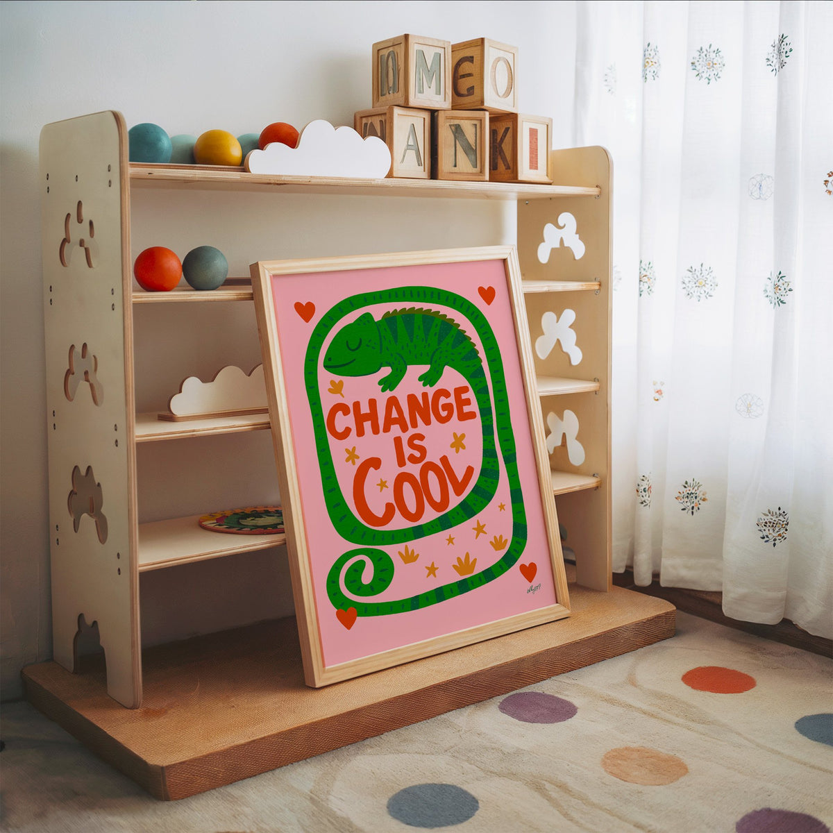 Change is cool chameleon pink nursery print in an oak frame leaning on a toy shelf with wooden letter blocks