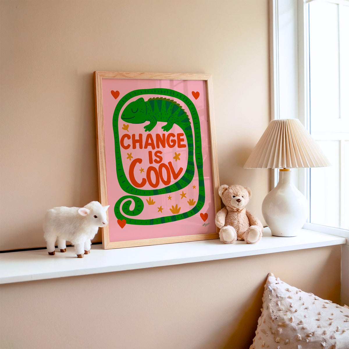 Change is cool chameleon pink nursery print in an oak frame on a window ledge with a toy lamb and teddy